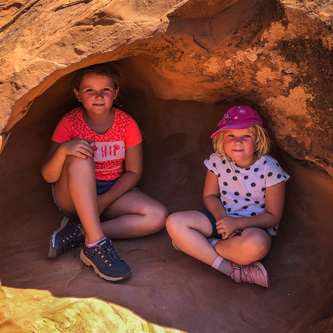 Die Kinder in einer schattigen Felshöhle